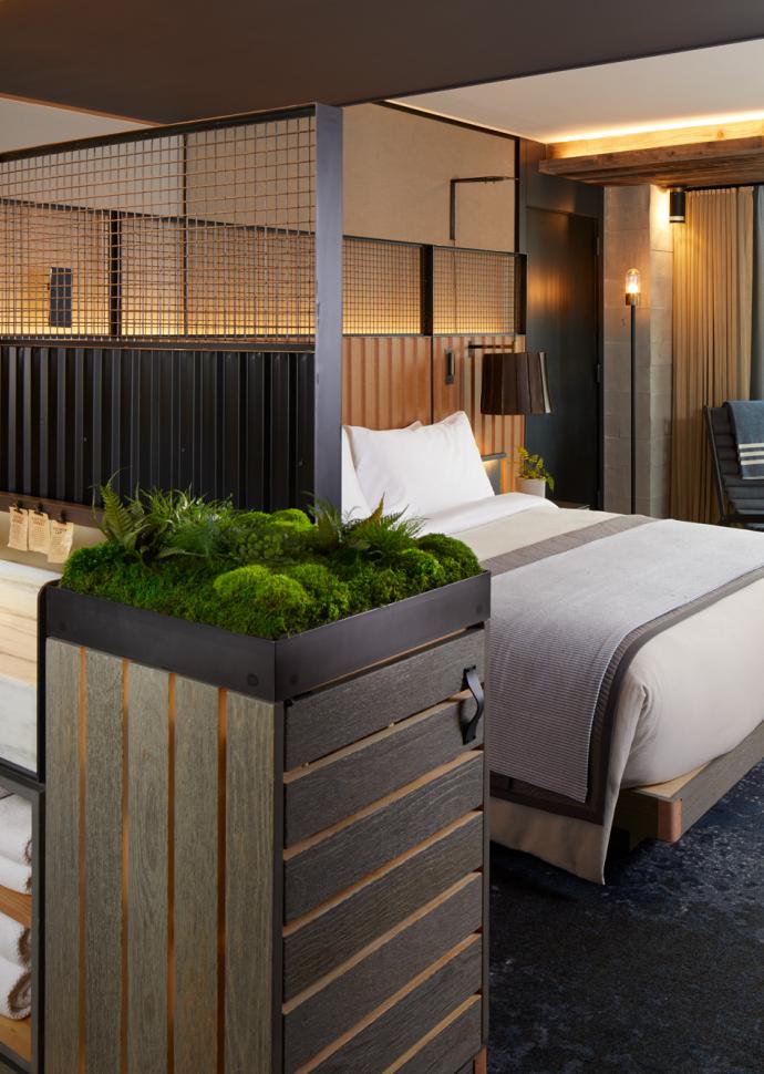 A king sized bed in a suite with a view of the Manhattan skyline